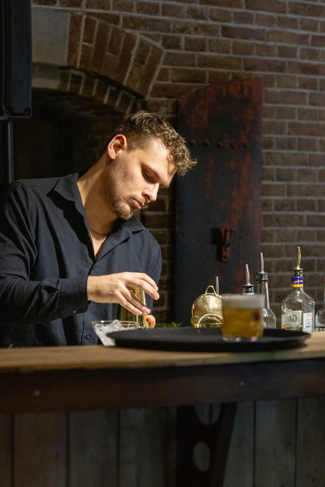 Bartender maakt een cocktail af achter de bar tijdens een avondevenement